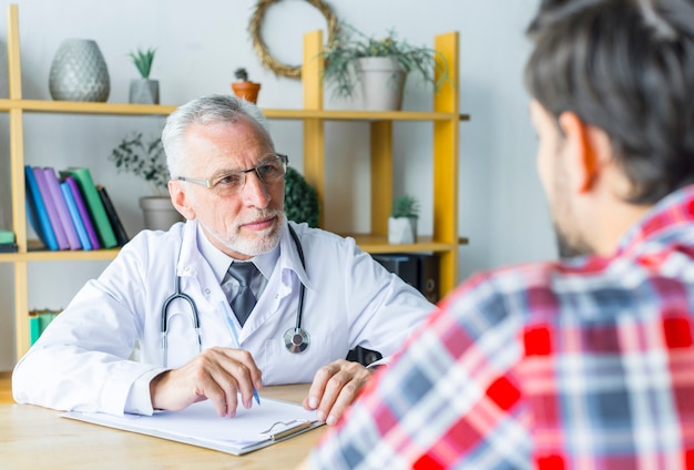 Bearded doctor listening to patient