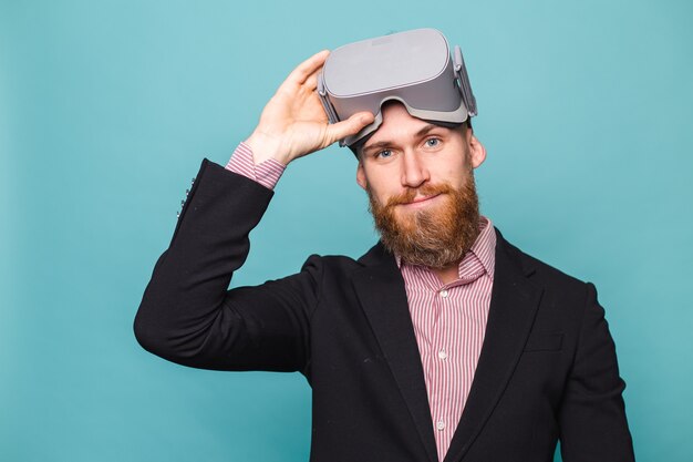 Bearded european businessman in dark suit isolated, wearing vr glasses on head with excited happy face