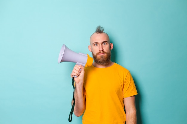 Bearded european man in yellow shirt isolated, hold megaphone