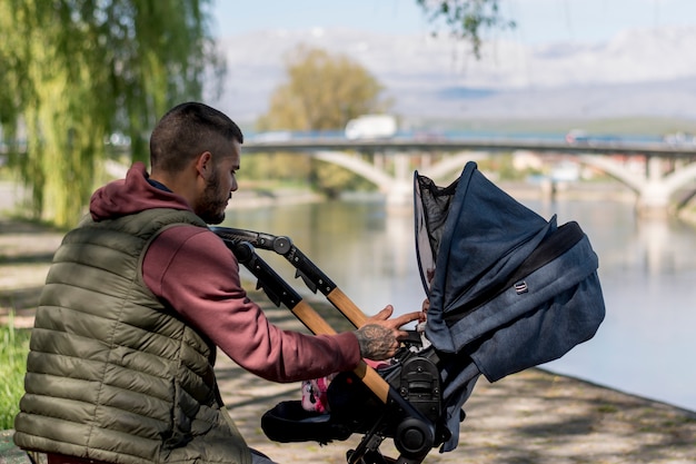 Free photo bearded father and baby carriage