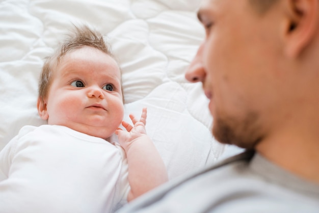 Bearded father lying with baby