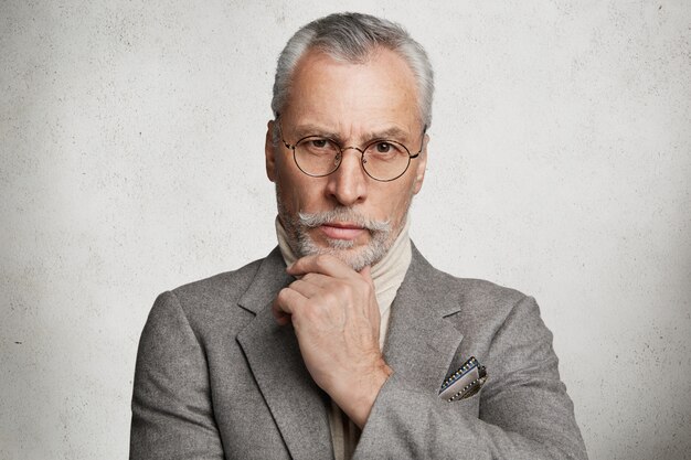 Bearded grey-haired elderly man dressed in formal suit