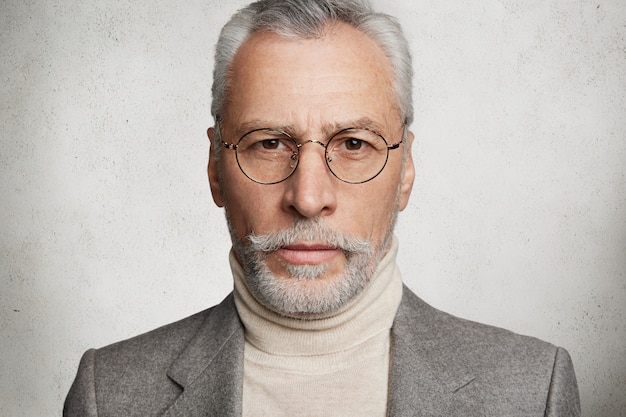 Bearded grey-haired elderly man dressed in formal suit