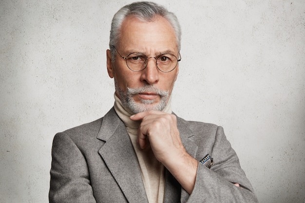 Bearded grey-haired elderly man wearing formal suit