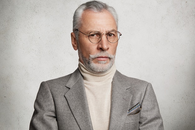 Bearded grey-haired elderly man wearing formal suit