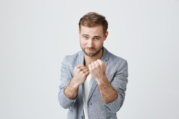 Bearded guy ready to fight, clench fists, stand boxer pose