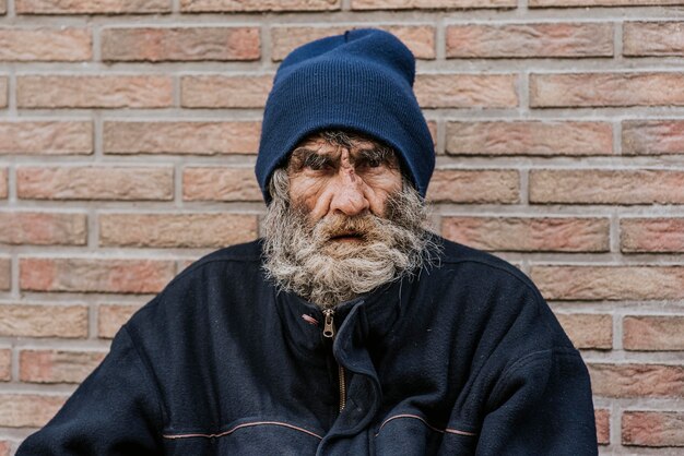 Бородатый бездомный перед стеной