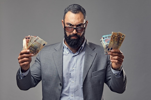 bearded male dressed in a suit catch money banknote in the air.