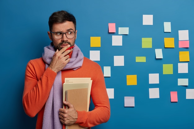 Bearded male organizing his tasks using sticky notes