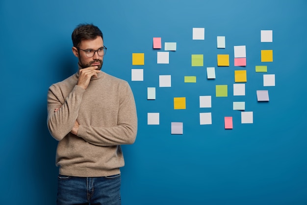 Bearded male organizing his tasks using sticky notes