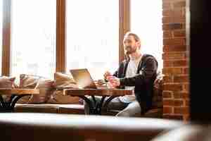 Free photo bearded man in cafe with laptop