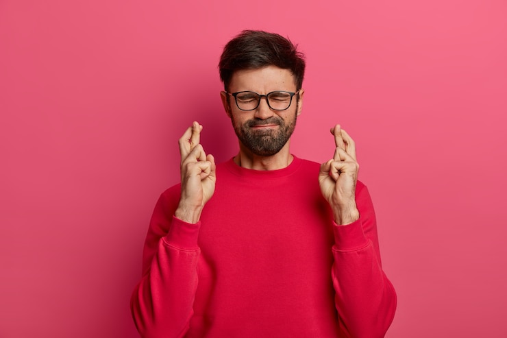 Free Photo bearded man crosses fingers, hopes for best, presses lips, believes in good luck
