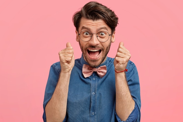 Foto gratuita uomo barbuto in camicia di jeans e papillon rosa