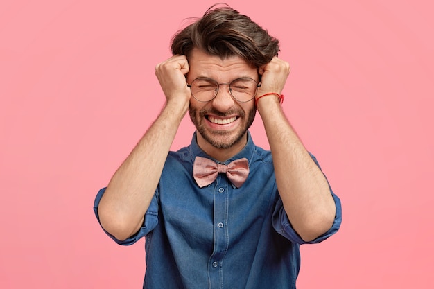 Bearded man in denim shirt and pink bowtie