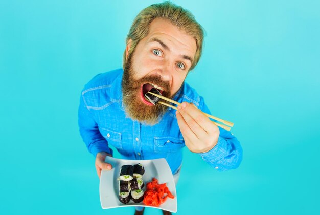 젓가락으로 스시를 먹는 수염 난 남자 일본 음식 맛있는 식사 스시 배달 음식 테이크 아웃