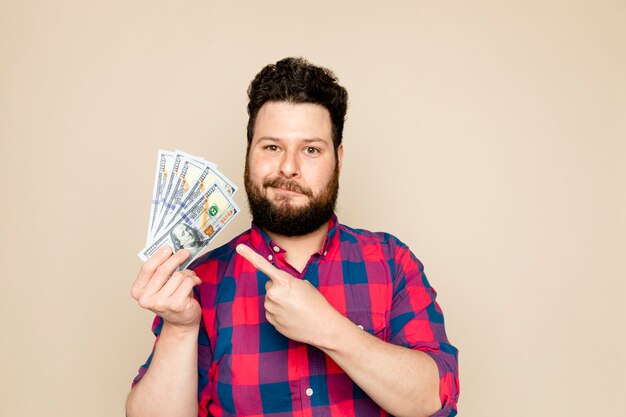 Free photo bearded man holding dollar notes for financial savings campaign