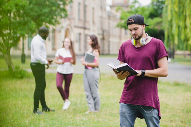 Bearded man holding textbook reading standing