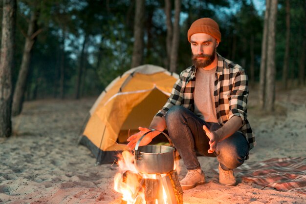 Bearded man looking at bonfire