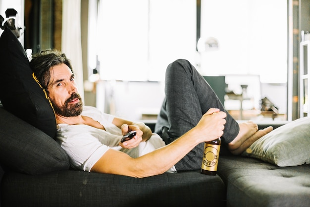 ビールを飲んだ男がコーチにビールを飲みながら