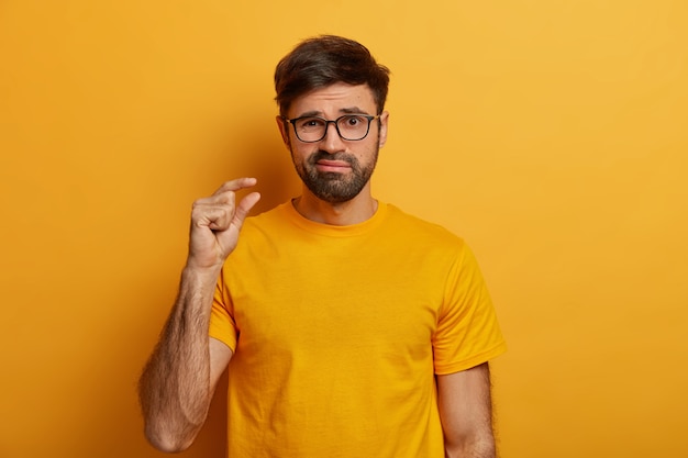 Bearded man makes hand gesture, advice to have small amount of something