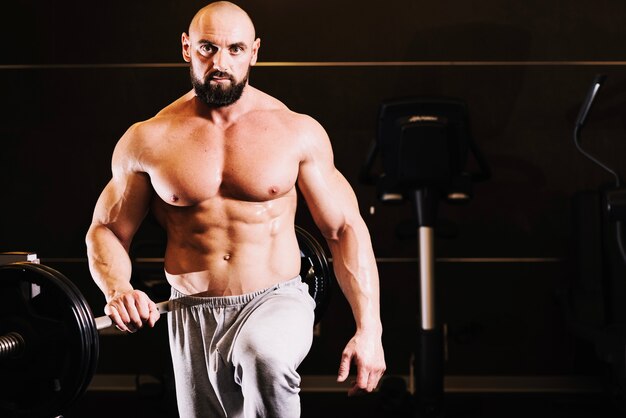 Bearded man posing near barbell