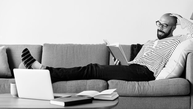 Bearded man reading on the couch