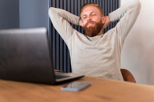 Бородатый мужчина отдыхает в офисе