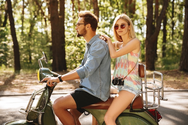 Bearded man on scooter with womanfriend outdoors