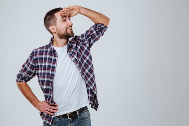 Uomo barbuto in camicia che guarda da parte