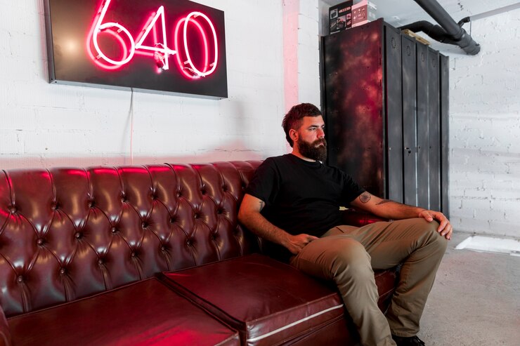 Free Photo bearded man sitting on couch in barbershop