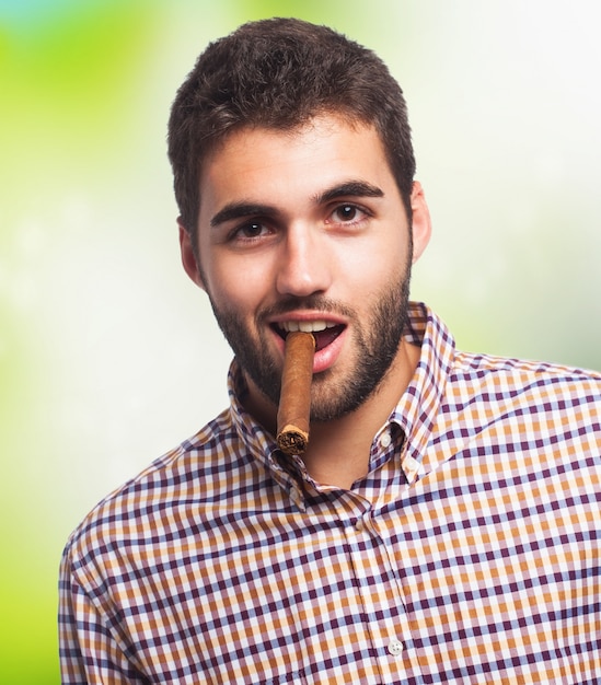 Bearded man smokes cigar.