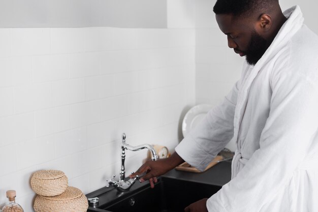 Bearded man turning tap water on