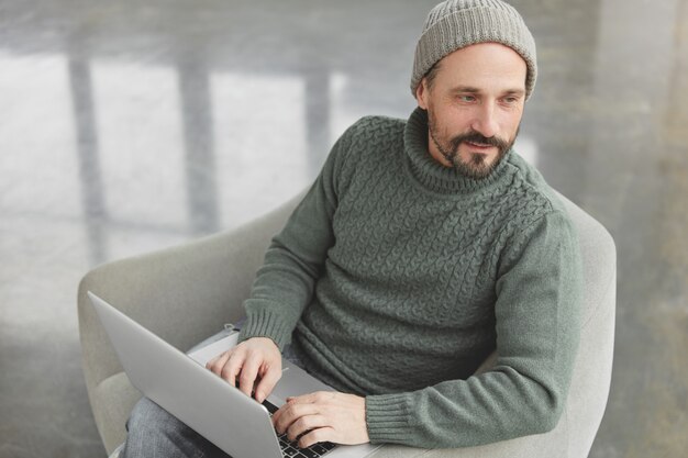 Bearded man wearing knitted warm sweater and hat