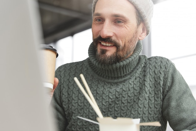 Bearded man wearing knitted warm sweater and hat