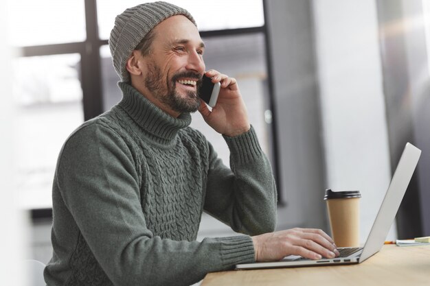 Bearded man wearing knitted warm sweater and hat