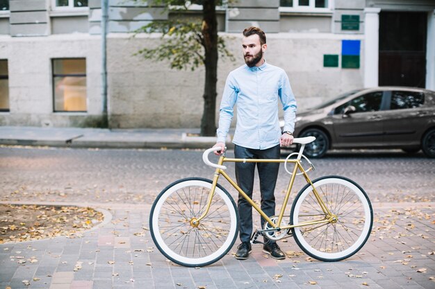 街頭に自転車を立てたひげのある男