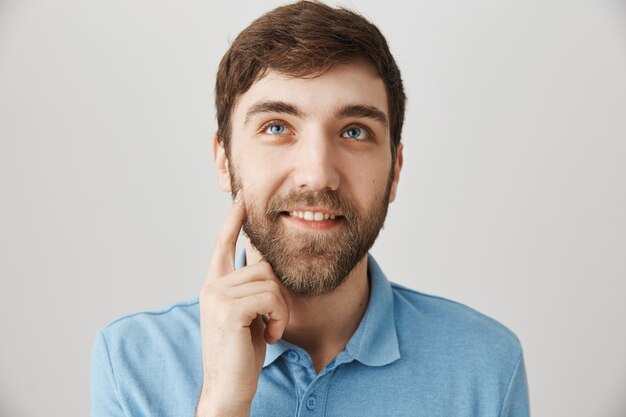 Бородатый портрет молодого парня в голубой футболке