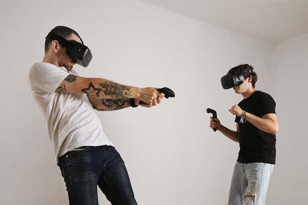 Free photo a bearded tattooed man in a white t-shirt hits a younger man in a black t-shirt in a vr game