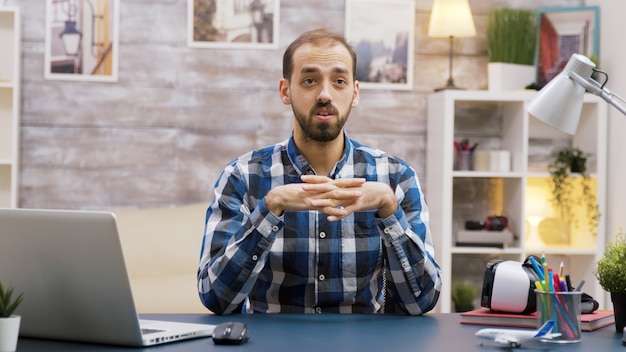 Vlogger barbuto che registra un nuovo episodio per i social media. influencer che parla con la telecamera.