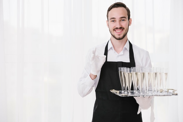 Bearded waiter holding metal tray