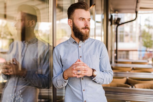 Bearded young man standing in restaurant