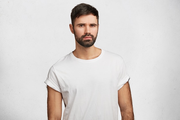 흰색 티셔츠를 입고 수염 된 젊은 남자
