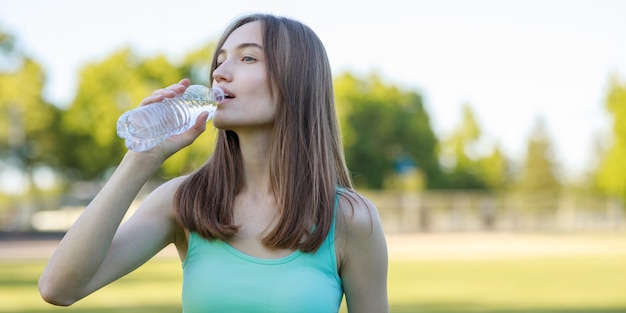Красивая дама пьет воду после занятий спортом