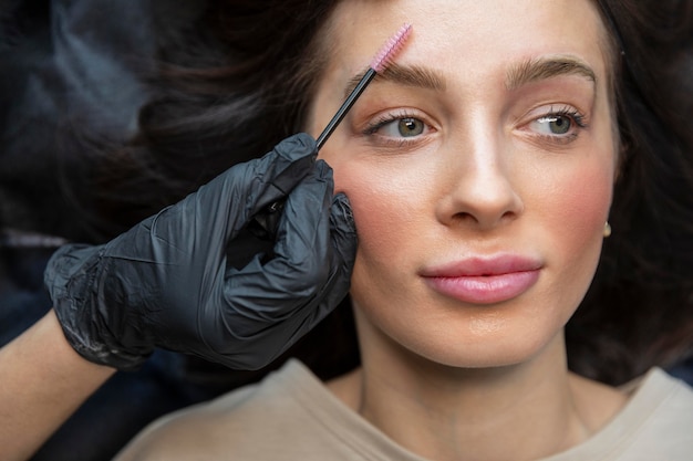Бесплатное фото Косметолог делает лечение бровей для своего клиента