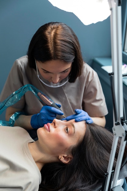 Beautician doing an eyebrow treatment for her client