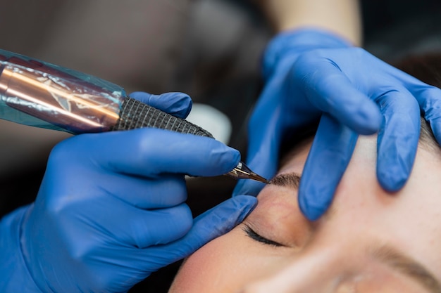 Косметолог делает лечение бровей своей клиентке