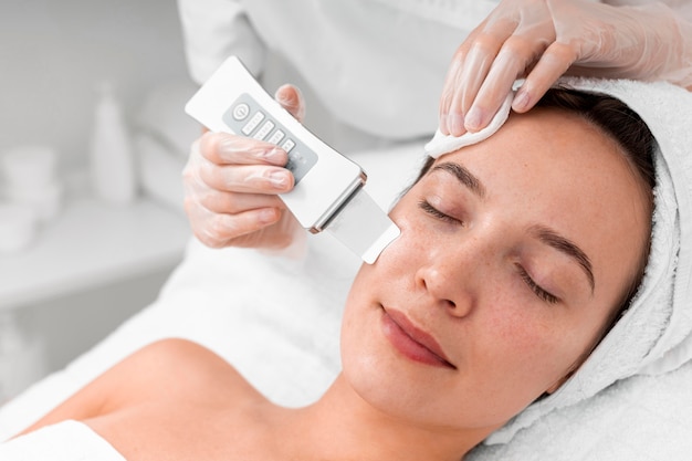 Beautician doing face beauty routine for female client