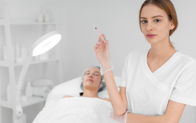 Beautician doing injection filler on female client at salon