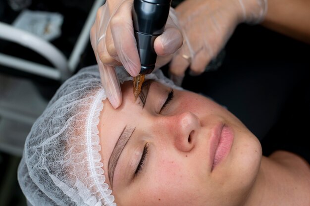 Beautician doing a microblading procedure on a woman at a beauty salon