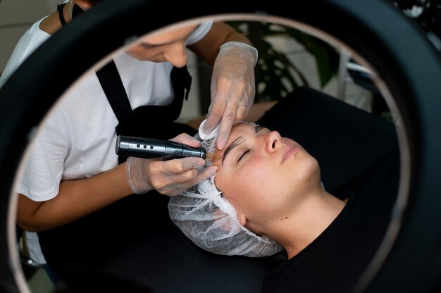 Beautician doing a microblading procedure on a woman at a beauty salon